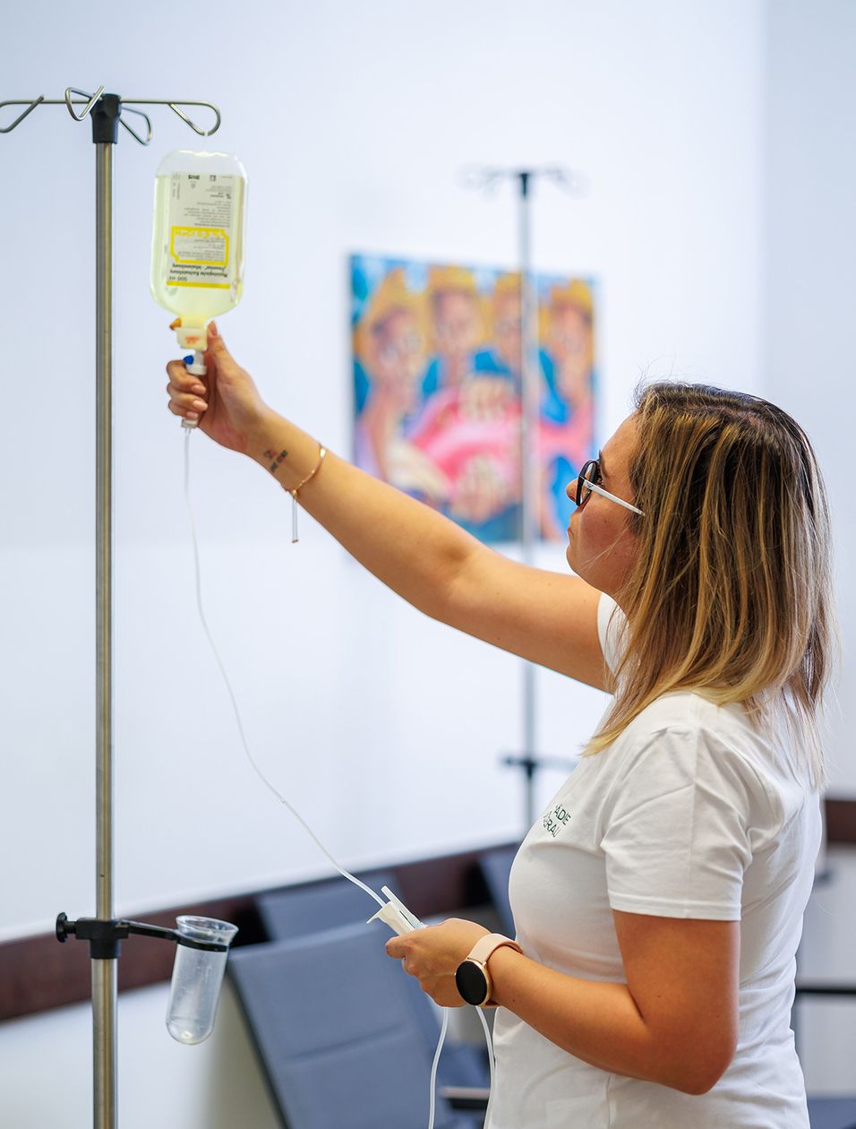 Eine Mitarbeiterin hängt eine Infusion an